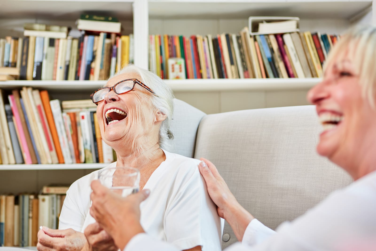 Nurse And Happy Senior Woman Laughing Together In Retirement Hom The